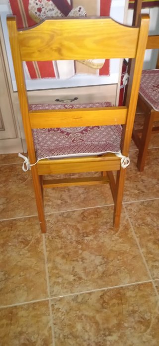 Mesa de madera con tapa de cristal y cuatro sillas