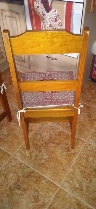 Mesa de madera con tapa de cristal y cuatro sillas