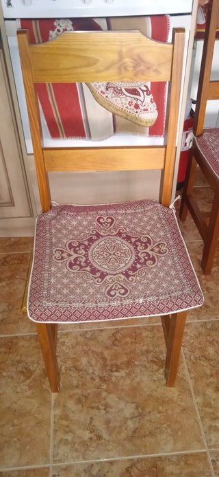 Mesa de madera con tapa de cristal y cuatro sillas