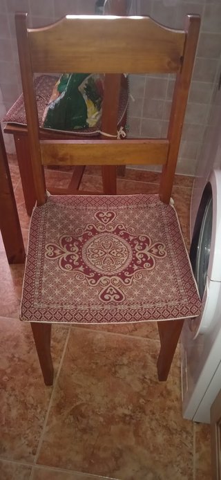 Mesa de madera con tapa de cristal y cuatro sillas