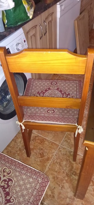 Mesa de madera con tapa de cristal y cuatro sillas