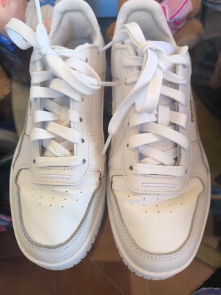 Zapatillas Puma Blancas y letras Doradas