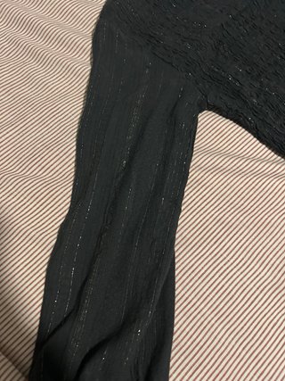 Top negro asimétrico con detalles dorados