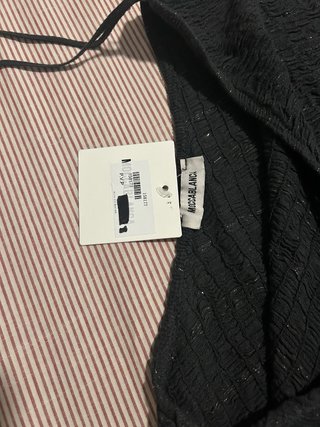Top negro asimétrico con detalles dorados