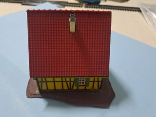 Casetta in miniatura gialla con tetto rosso