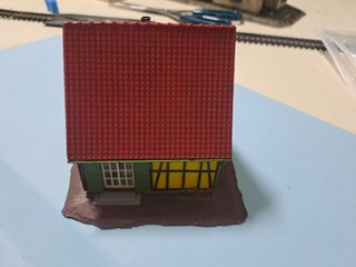 Casetta in miniatura gialla con tetto rosso