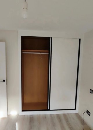 Armario empotrado beige y blanco.