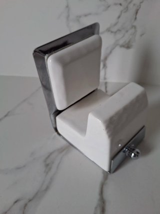 Percha de baño plateada y blanca
