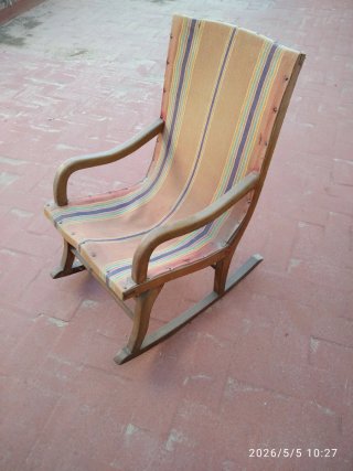 Vecchia sedia a dondolo in legno e tessuto