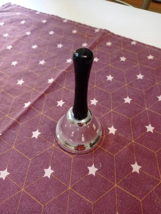 Campana de mano plateada con mango negro