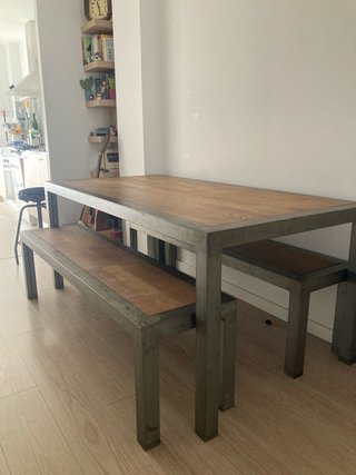 Mesa comedor y bancos de madera y metal.