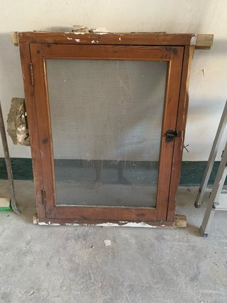 Ventana antigua de madera con mosquitera