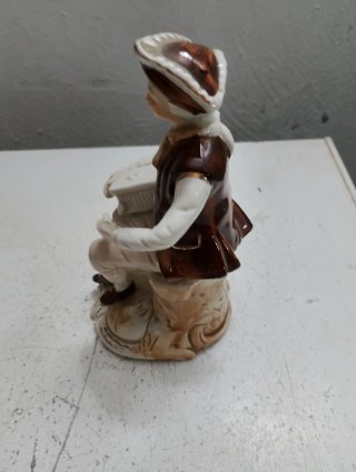 Figura de porcelana de hombre sentado