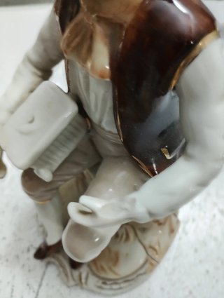 Figura de porcelana de hombre sentado