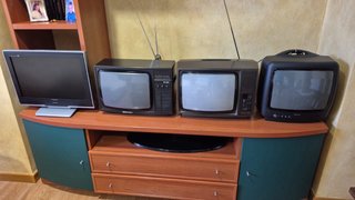 Cuatro televisores antiguos y vídeos VHS todo