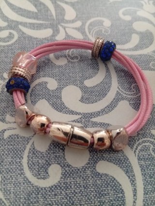 Pulsera de cordón rosa con abalorios dorados