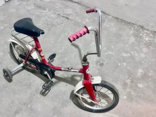 Bicicleta infantil roja con ruedines roja