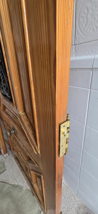 Puerta de madera maciza con ventanita y reja