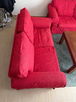 Sofás rojos, mesa de madera y alfombra