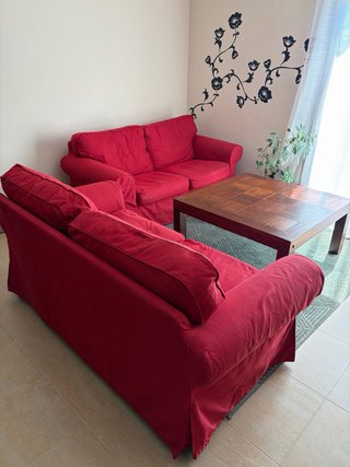 Sofás rojos, mesa de madera y alfombra