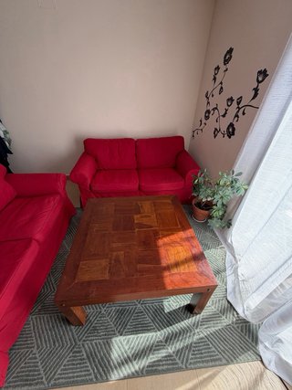 Sofás rojos, mesa de madera y alfombra