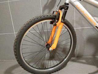 Bicicleta infantil plateada con horquilla naranja