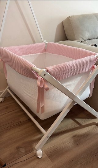 Vestidura para minicuna rosa y blanca.