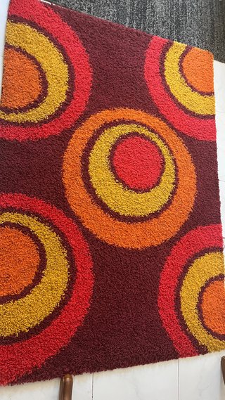 Alfombra naranja roja y amarilla con circulos