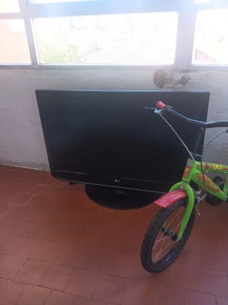 Bici infantil verde y roja y una tele Lg