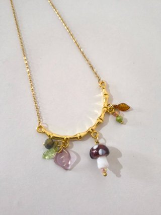 Collana con ciondoli fungo e foglie con ramo.