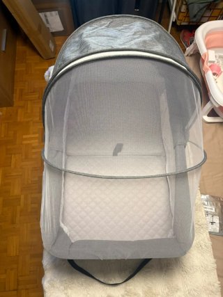 Cuna de viaje gris con mosquitera