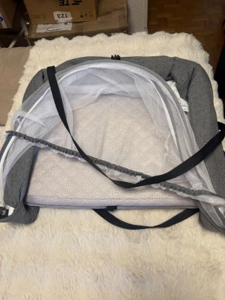 Cuna de viaje gris con mosquitera