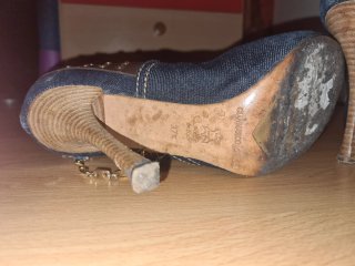 Zapatos de tacón vaqueros con adornos dorados.