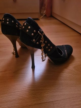 Zapatos de tacón vaqueros con adornos dorados.