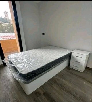 Cama individual blanca con mesita