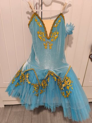 Traje de patinaje artístico azul y dorado