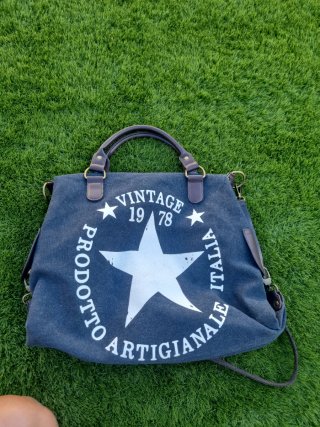 Bolso gris marengo con remaches de cuero marrones.