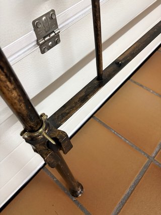 Cabecero antiguo de metal con detalles de latón