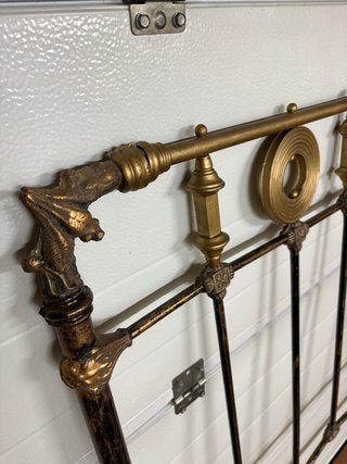 Cabecero antiguo de metal con detalles de latón