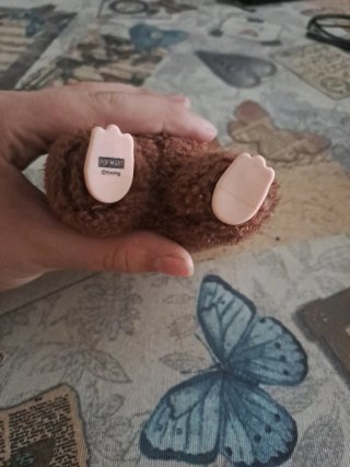 Labubu marrón secreto con 2 prenda y un lazo.