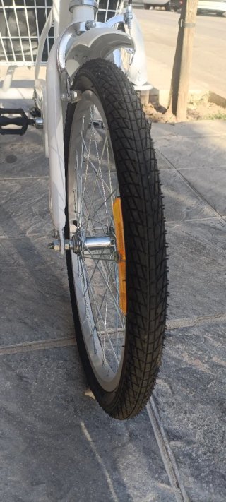Bicicleta de tres ruedas blanca con cesta