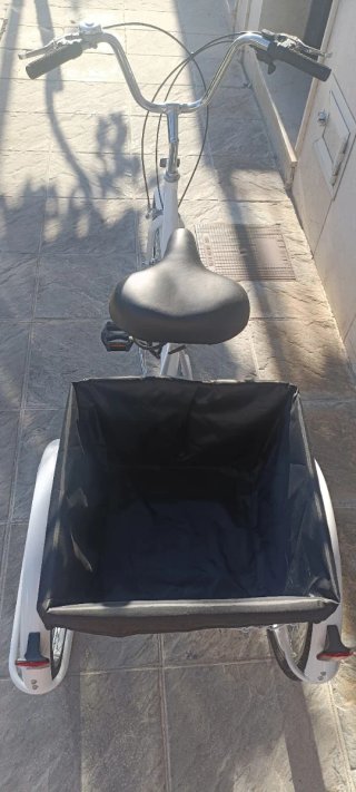Bicicleta de tres ruedas blanca con cesta