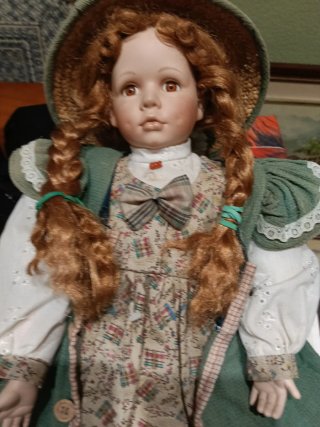 Muñeca de porcelana con traje y sombrero