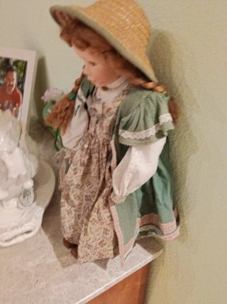 Muñeca de porcelana con traje y sombrero