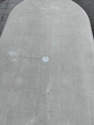 Mesa de jardín ovalada blanca y cuatro sillas.