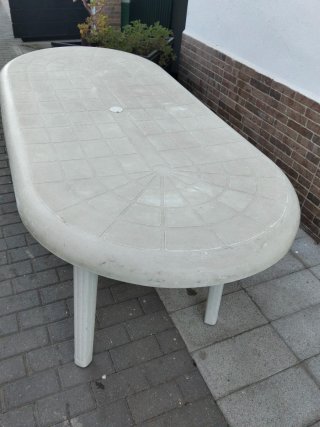 Mesa de jardín ovalada blanca y cuatro sillas.