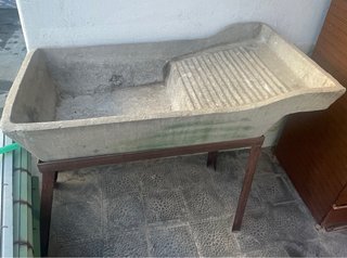 Pila de piedra antigua con tabla de lavar