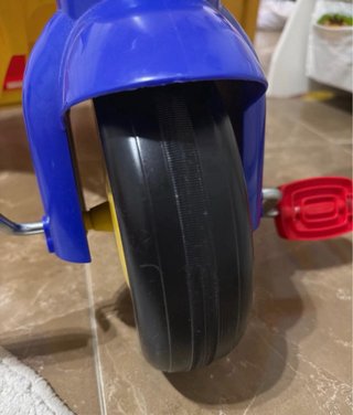 Triciclo infantil amarillo, azul y rojo