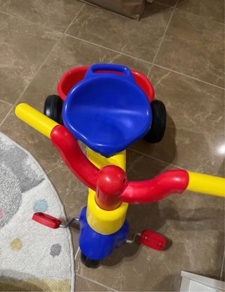 Triciclo infantil amarillo, azul y rojo