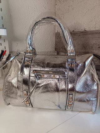 Bolso plateado con cremallera y tachuelas